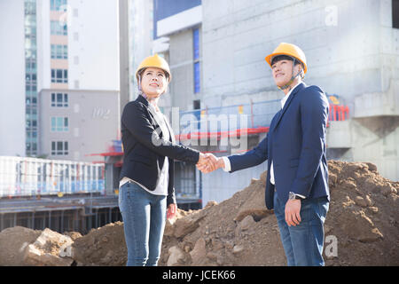Two architects shaking hands with each other at construction site Stock Photo