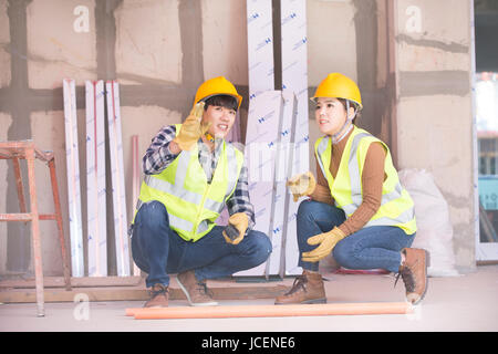 Construction workers squatting talking Stock Photo