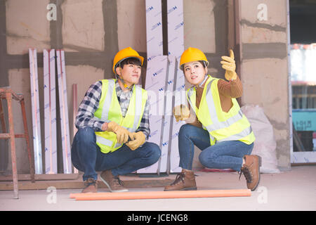 Construction workers squatting talking Stock Photo