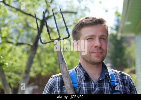 Portrait of a handsome mature man gardening in garden, on summer day Stock Photo