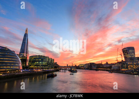 A beautifully sunny day ends with a stunning sunset sky in a panorama over City Hall, the Shard, City of London and the River Thames in London, UK Stock Photo