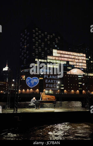 Hamburg, Germany. 16th June, 2017. Greenpeace activists project a heart-shaped earth with the demand 'Planet Earth First' on to the Elbphilharmonie (Elbe Philharmonic Hall) in Hamburg, Germany, 16 June 2017. At the same time Rumanian-Israeli pianist Michael Abramovich played Frédéric Chopins Nocturne op. 9, Nr. 2 in E flat major on a concert grand on the Elbe River. Photo: Georg Wendt/dpa/Alamy Live News Stock Photo