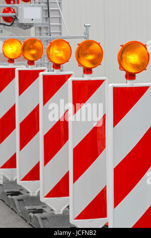 Roadworks barrier with amber beacon flashing lights Stock Photo