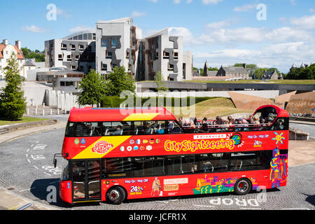 Tourist bus outside the Scottish Parliament building at Holyrood in Edinburgh, Scotland, United Kingdom. Stock Photo