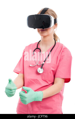 Female nurse wearing virtual reality goggles playing games  isolated on white background Stock Photo