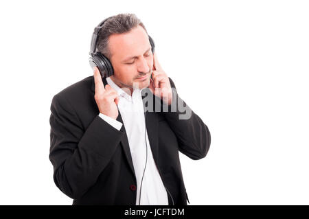 Attractive man with headphones listening his favorite music and relaxing on white studio background Stock Photo