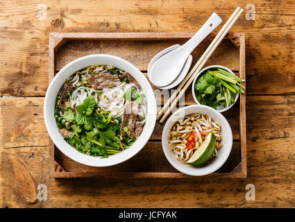 Pho Bo vietnamese Soup with beef in wooden tray on wooden background Stock Photo