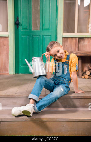 Little girl sitting on a porch barefoot Stock Photo - Alamy