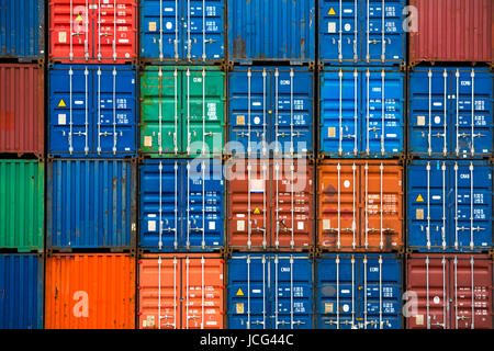 Four vertical rows of shipping containers that are different colors in the Port of Zeebrugge, Belgium Stock Photo
