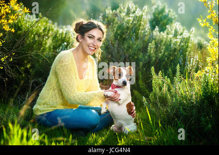 Girl walking with a hunting dog - the Jack Russell Terrier . Close-up. Spring. Copy space. Stock Photo