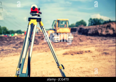 Surveying measuring equipment level theodolite on tripod at building site Stock Photo