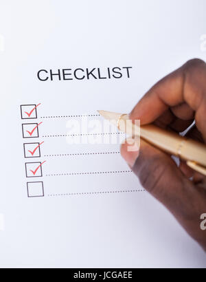 Close-up Of A Person's Hand Marking With Pen On Check Box Stock Photo