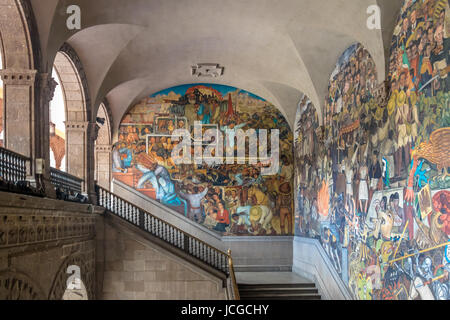 The stairs of National Palace with the famous mural 'Class Struggle' and 'The History of Mexico' by Diego Rivera - Mexico City, Mexico Stock Photo