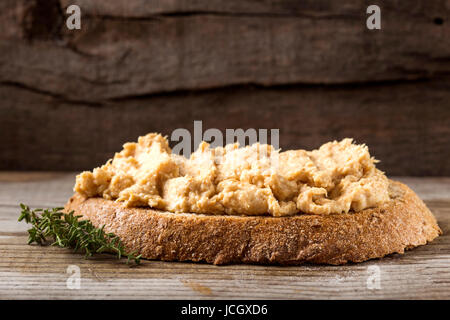Fresh homemade chicken liver pate on bread over rustic background Stock Photo