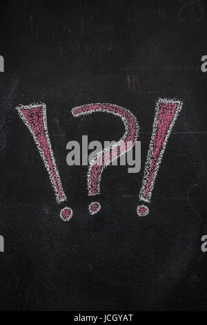 White and red question and exclamation marks drawn with chalk on blackboard Stock Photo