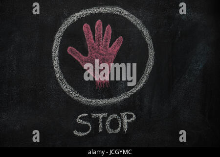 Hand shape and stop word in the circle drawn with red chalk on blackboard Stock Photo