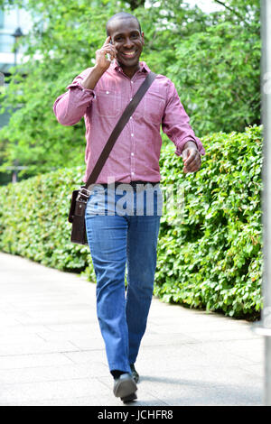 Handsome man walking and talking on the phone Stock Photo