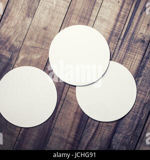 Three blank beer coasters on vintage wooden table background. Responsive design mockup. Top view. Stock Photo