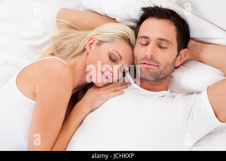Beautiful young couple relaxing in bed at home Stock Photo