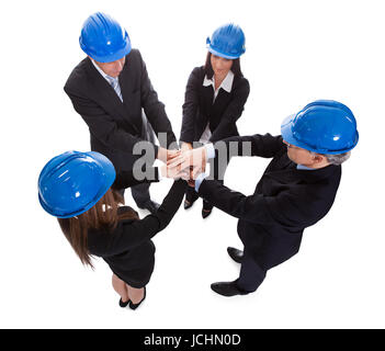 Group Of Architects Stacking Hand Over Each Other On White Background Stock Photo