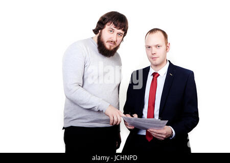 two builders standing and discussing new project held by one of them. Stock Photo