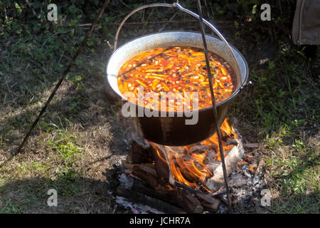 Cooking bean goulash in a caldron on open flame Stock Photo