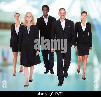 Group Of Happy Businesspeople Walking Towards Camera Stock Photo