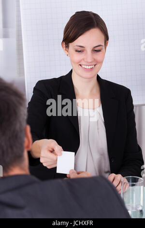 Happy Businesswoman Exchanging Visiting Card With Businessman Stock Photo