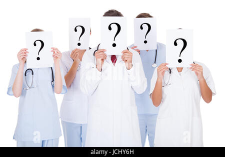 Group Of Doctors Hiding Face With Question Mark Sign Over White Background Stock Photo