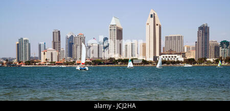 Prominent architecture stands at the waterfront in San Diego as sailboats sail the bay Stock Photo