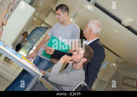 smiling teacher with two students in classroom Stock Photo