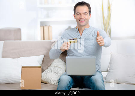 portrait of a man shopping online with the thumb up Stock Photo