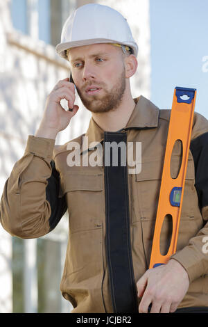 young architect supervising a construction talking on cell phone outdoors Stock Photo