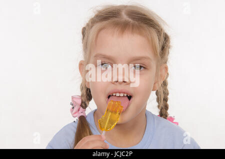 the five-year old girl enthusiastically eats candy Stock Photo