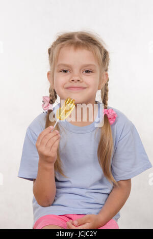 the five-year old girl enthusiastically eats candy Stock Photo