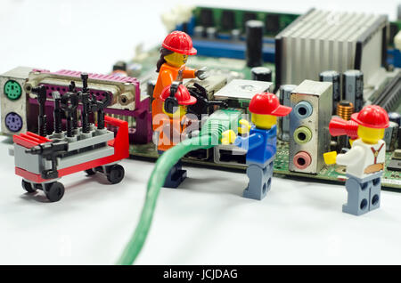 Minifig worker plug in internet cable to port Stock Photo