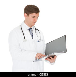Young Male Doctor Checking Records Over White Background Stock Photo