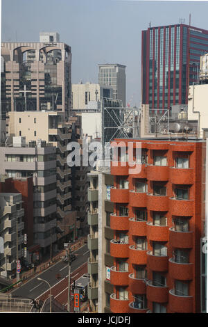 Tenth floor view of the street and urban area near Tamachi Station in Tokyo, Japan, where there are many apartment buildings and several skyscrapers. Stock Photo