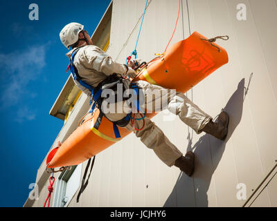 Crews practice high angle rescue at a public training facility at an industrial site in Oregon using ropes, litters and rappelling techniques. Stock Photo