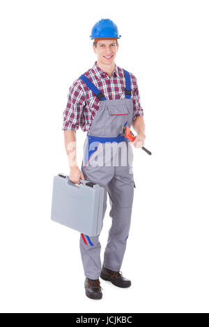 Happy Worker Holding Toolkit And Wrench Over White Background Stock Photo