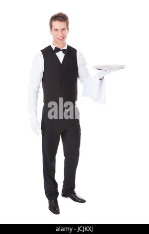 Young Male Waiter Standing With Cloche Lid Cover Over White Background Stock Photo