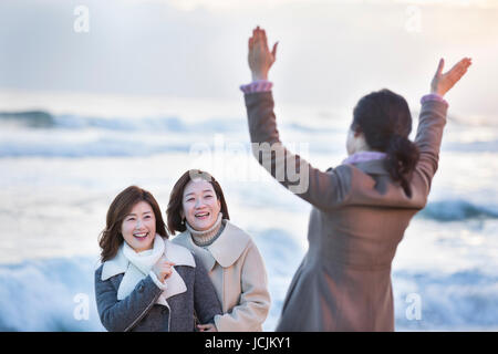 Three smiling middle aged women on beach Stock Photo