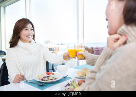 Portrait of smiling middle aged women toasting with juice Stock Photo
