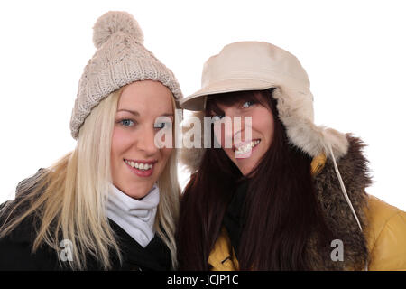 Zwei lachende Frauen im Winter mit Mütze und Schal, isoliert vor einem weissen Hintergrund Stock Photo