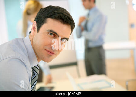 Confident businessman leaning on table Stock Photo
