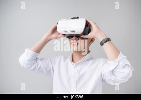 Excited asian man in a VR goggles and gesturing with his hands Stock Photo