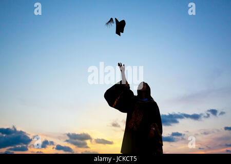 Silhouette Of Young Female Student Celebrating Graduation Stock Photo