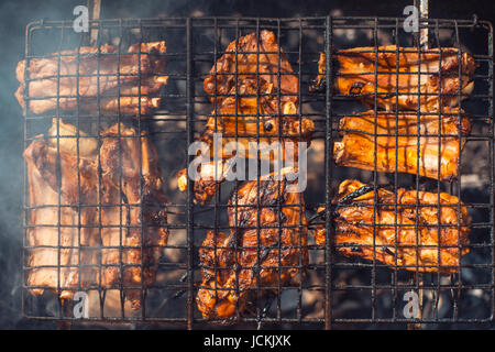 Tasty Grilled pork ribs on the grill barbecue top view. under bright summer sun Stock Photo