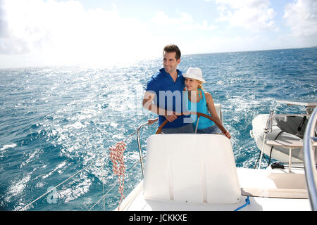 Young couple navigating on a yacht in caribbean sea Stock Photo