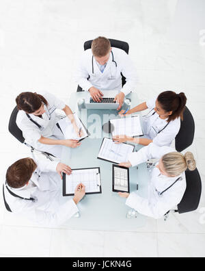 High angle view of doctors analyzing medical reports at desk in clinic Stock Photo